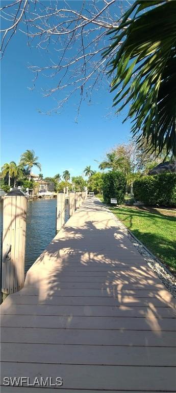 wooden terrace featuring a boat dock and a water view