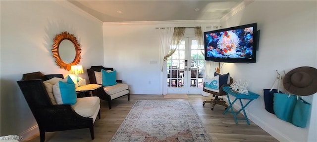 living area with crown molding, wood-type flooring, and french doors