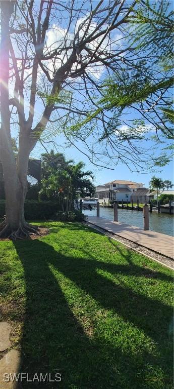 view of yard with a boat dock and a water view