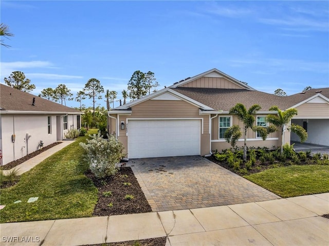 single story home featuring a garage and a front lawn