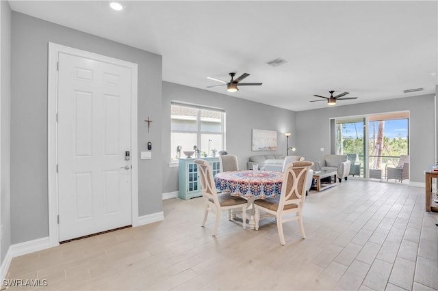 dining space with light hardwood / wood-style floors and ceiling fan