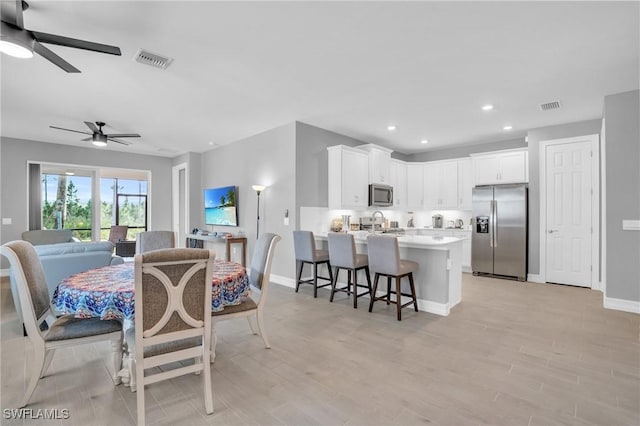 dining room featuring ceiling fan and light wood-type flooring