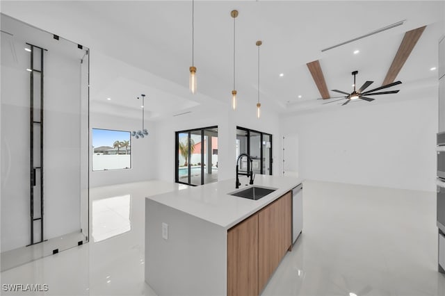 kitchen featuring decorative light fixtures, sink, stainless steel dishwasher, beam ceiling, and a spacious island