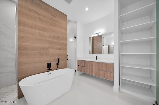 bathroom with vanity, separate shower and tub, and wood walls