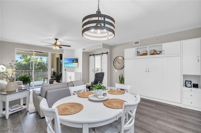 11041 Gulf Reflections Dr Unit 203, Fort Myers, FL 33908 - dining area featuring ceiling fan, a barn door, and dark hardwood / wood-style flooring