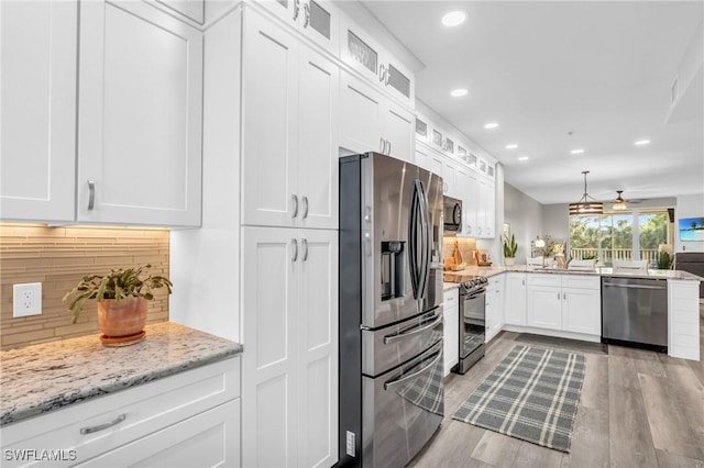 11041 Gulf Reflections Dr Unit 203, Fort Myers, FL 33908 - kitchen featuring pendant lighting, white cabinetry, stainless steel appliances, light stone counters, and tasteful backsplash