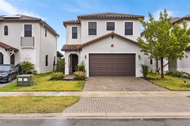 mediterranean / spanish home with a garage and a front yard