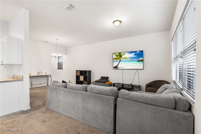 living room with light carpet and a notable chandelier