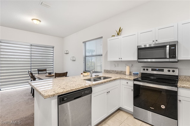 kitchen with white cabinetry, appliances with stainless steel finishes, kitchen peninsula, and sink