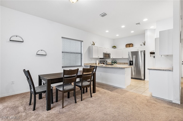 dining space featuring sink and light colored carpet