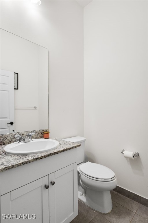 bathroom featuring vanity, tile patterned floors, and toilet