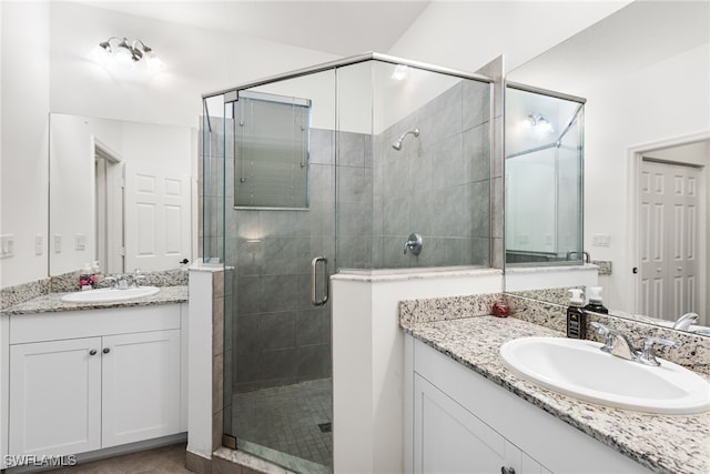 bathroom with vanity and a shower with door