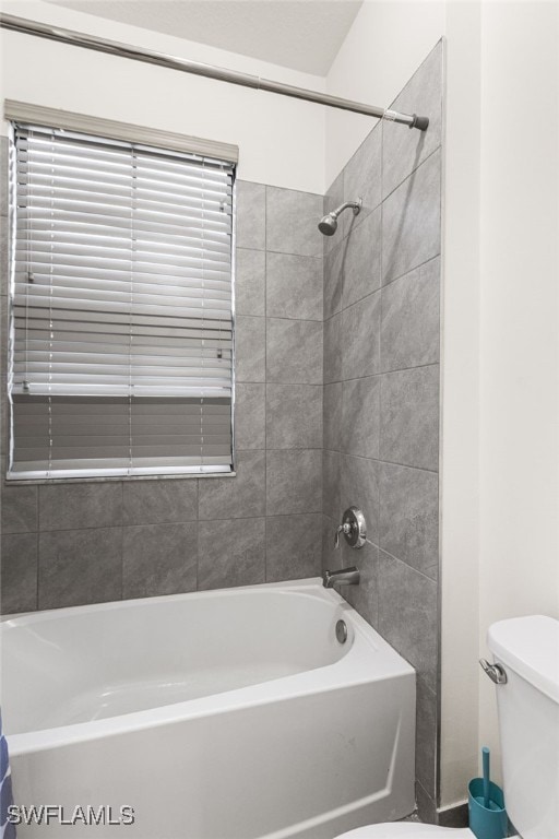 bathroom with toilet and tiled shower / bath combo