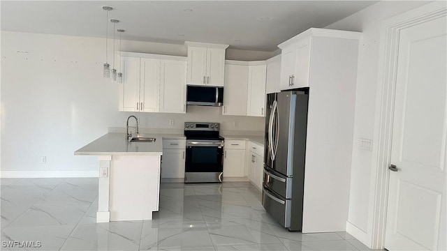 kitchen with pendant lighting, stainless steel appliances, sink, and white cabinets