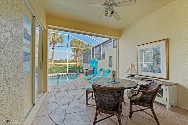 sunroom / solarium featuring ceiling fan and a swimming pool