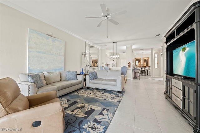 living room with ornamental molding, ceiling fan with notable chandelier, and light tile patterned floors