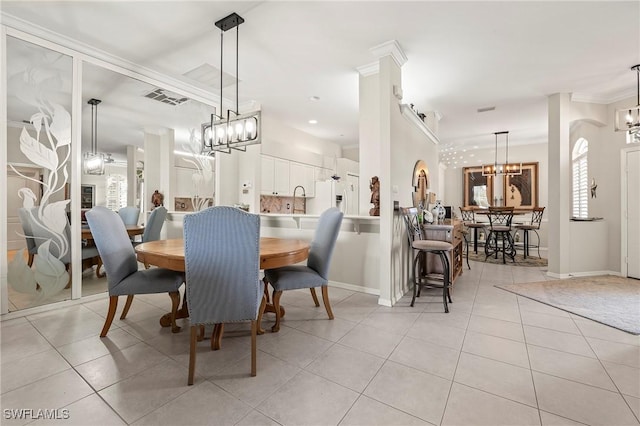 tiled dining space featuring an inviting chandelier, crown molding, and sink