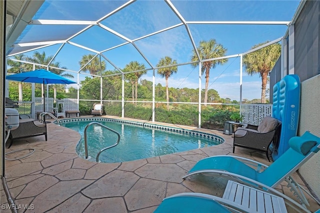 view of swimming pool featuring glass enclosure and a patio area