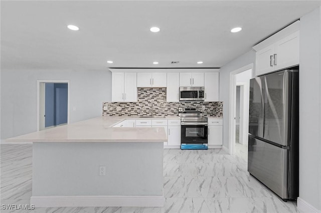 kitchen featuring white cabinetry, decorative backsplash, kitchen peninsula, and appliances with stainless steel finishes