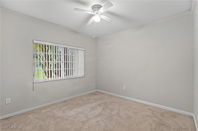 carpeted spare room featuring ceiling fan