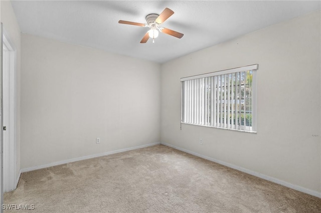 carpeted spare room with ceiling fan