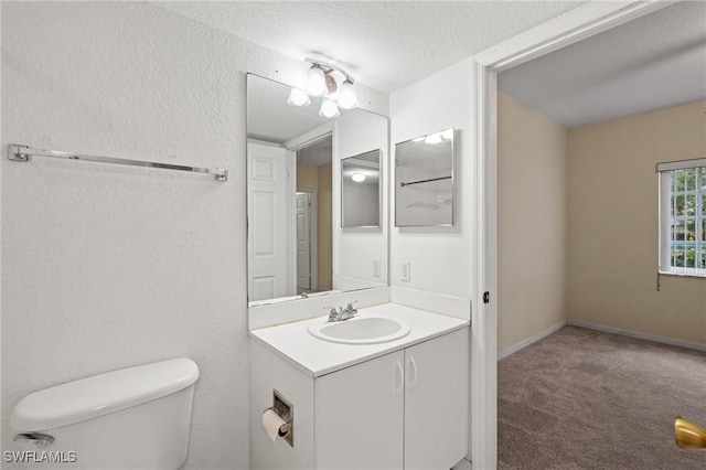 bathroom with vanity, a textured ceiling, and toilet