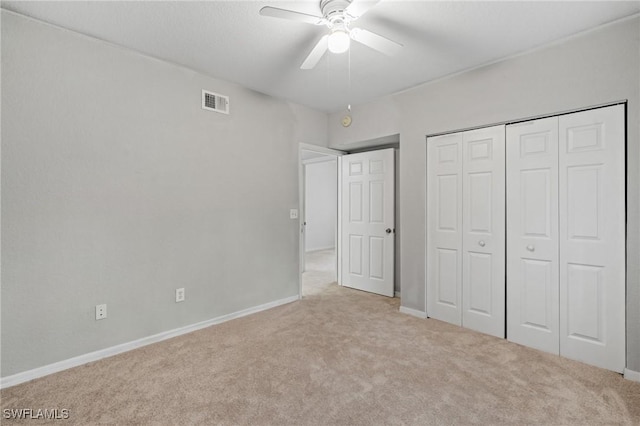 unfurnished bedroom featuring light carpet, a closet, and ceiling fan