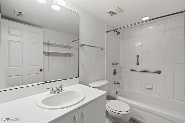 full bathroom with tiled shower / bath, vanity, and toilet