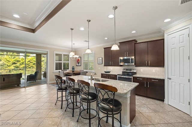 kitchen with a wealth of natural light, a breakfast bar area, appliances with stainless steel finishes, and a sink