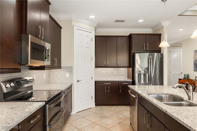 kitchen with stainless steel appliances, hanging light fixtures, ornamental molding, a sink, and dark brown cabinets