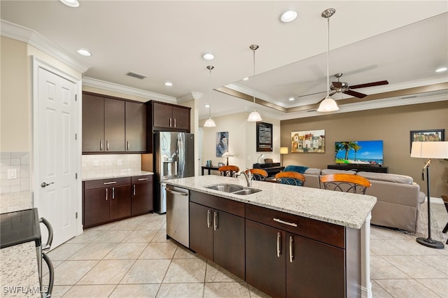 kitchen featuring visible vents, decorative backsplash, appliances with stainless steel finishes, open floor plan, and a sink