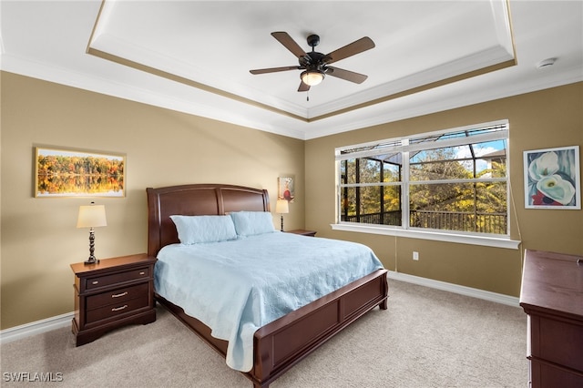 bedroom featuring baseboards, a tray ceiling, and light colored carpet