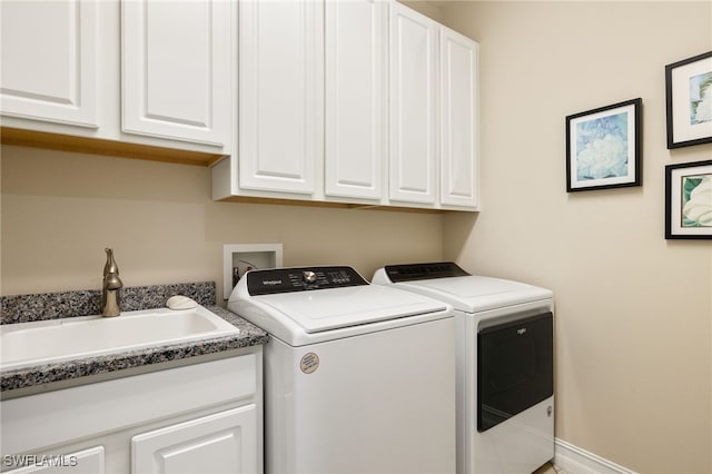 laundry area with cabinet space, a sink, baseboards, and separate washer and dryer