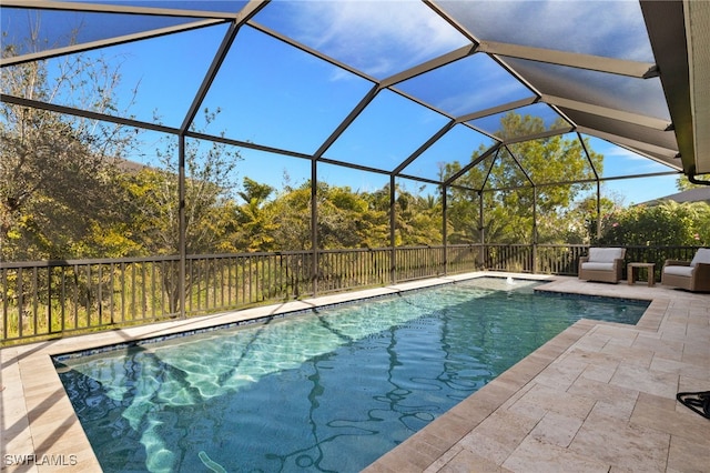 view of pool with a fenced in pool, glass enclosure, and a patio area