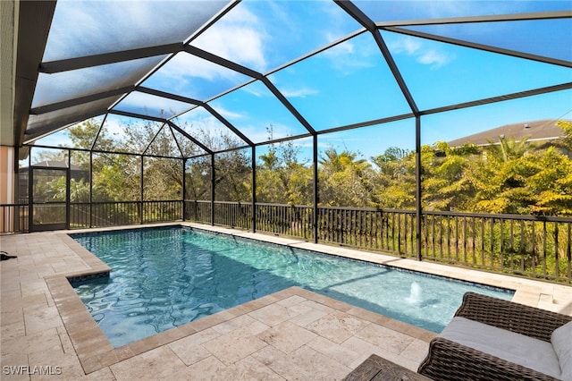 view of pool featuring a patio area, glass enclosure, and a fenced in pool