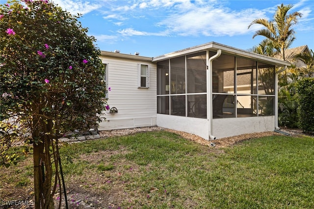 view of home's exterior featuring a sunroom and a lawn