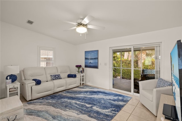 tiled living room with ceiling fan and lofted ceiling