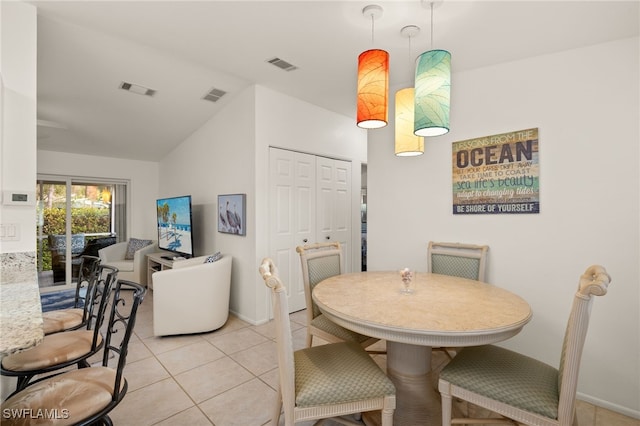 tiled dining space with vaulted ceiling