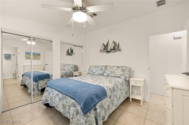 tiled bedroom with two closets and ceiling fan