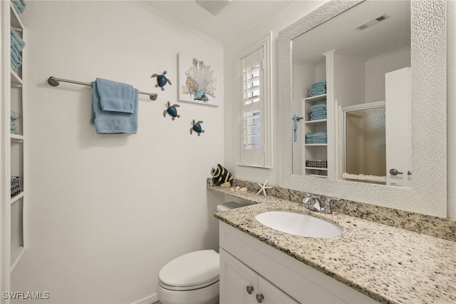 bathroom featuring vanity, crown molding, a shower with door, and toilet