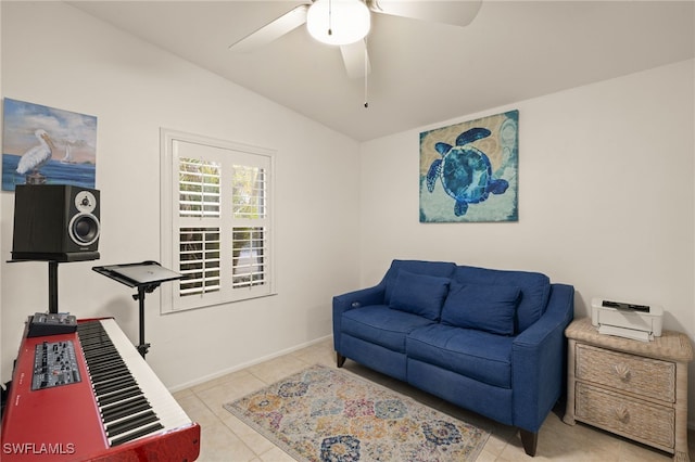 sitting room featuring vaulted ceiling, light tile patterned floors, and ceiling fan