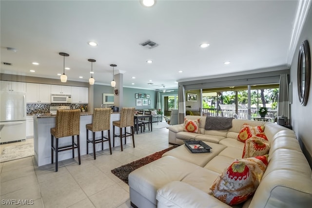 living room featuring light tile patterned floors, ceiling fan, and ornamental molding