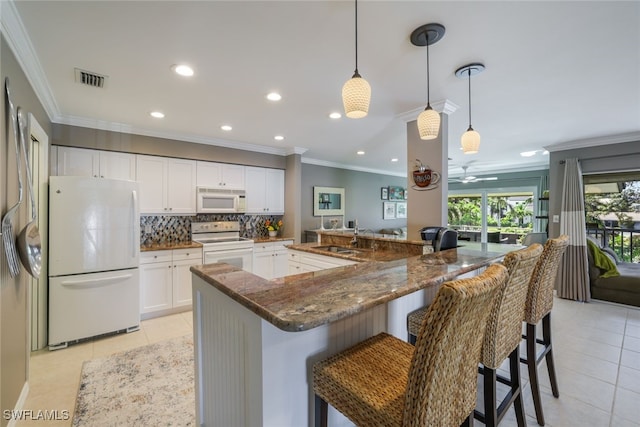 kitchen with white appliances, pendant lighting, white cabinets, and light tile patterned floors