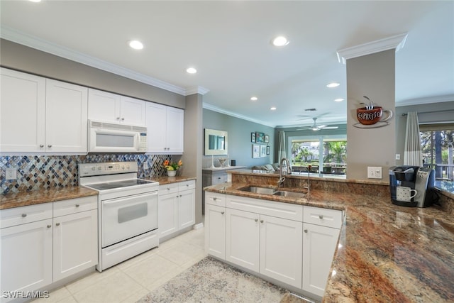 kitchen with white appliances, white cabinetry, sink, and dark stone counters