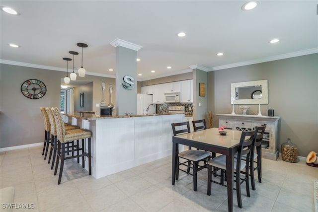 tiled dining room featuring crown molding