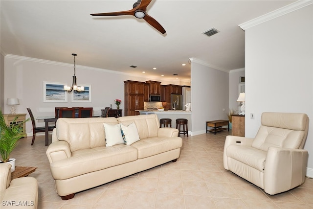 living room featuring light tile patterned flooring, ornamental molding, and ceiling fan with notable chandelier