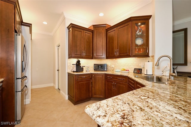 kitchen with light stone counters, sink, stainless steel fridge with ice dispenser, and tasteful backsplash