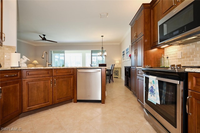 kitchen with stainless steel appliances, tasteful backsplash, light stone countertops, and ornamental molding