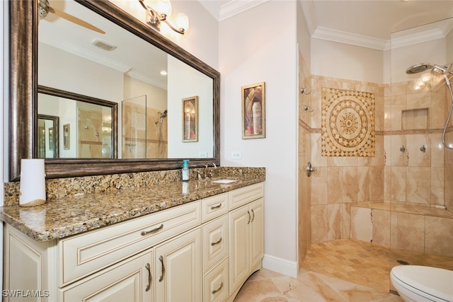 bathroom featuring vanity, ornamental molding, and a tile shower