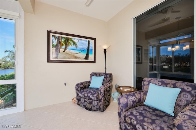 sitting room with ceiling fan, plenty of natural light, and light tile patterned floors